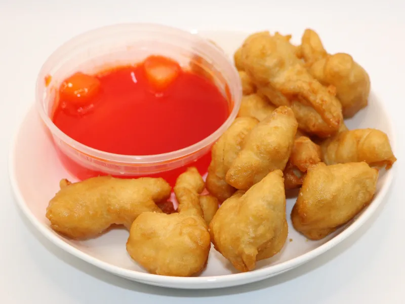 Crispy fried chicken pieces with sweet red dipping sauce at Wah Hing Kitchen, a Chinese Restaurant in South Ozone Park